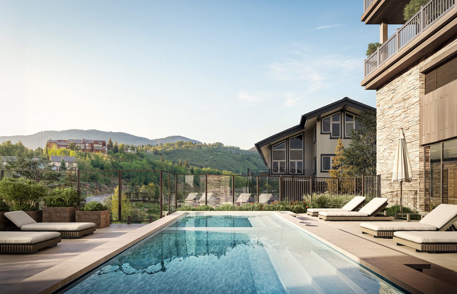 Wildair Owners Club outdoor pool with lounge chairs and views across the green Steamboat mountainside